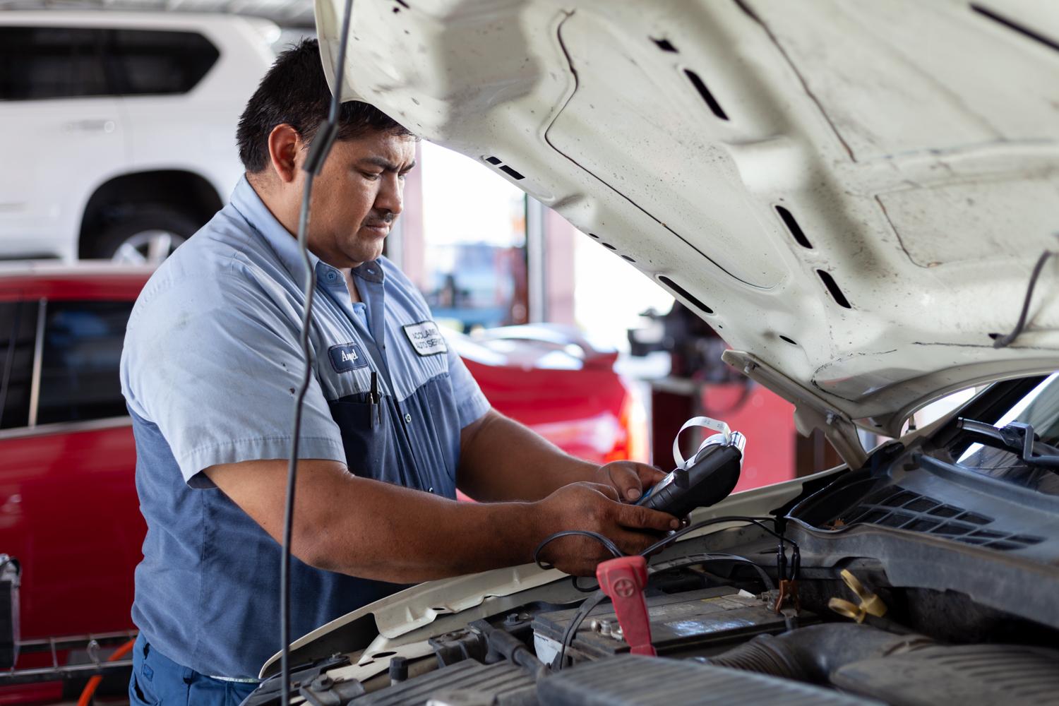 Acclaimed technician running diagnostics under the hood