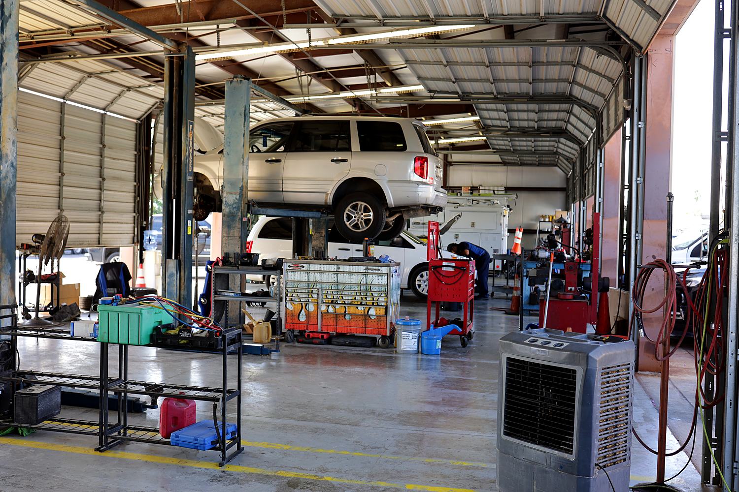 Inside the Acclaimed Auto Service bays, with a vehicle up on a lift