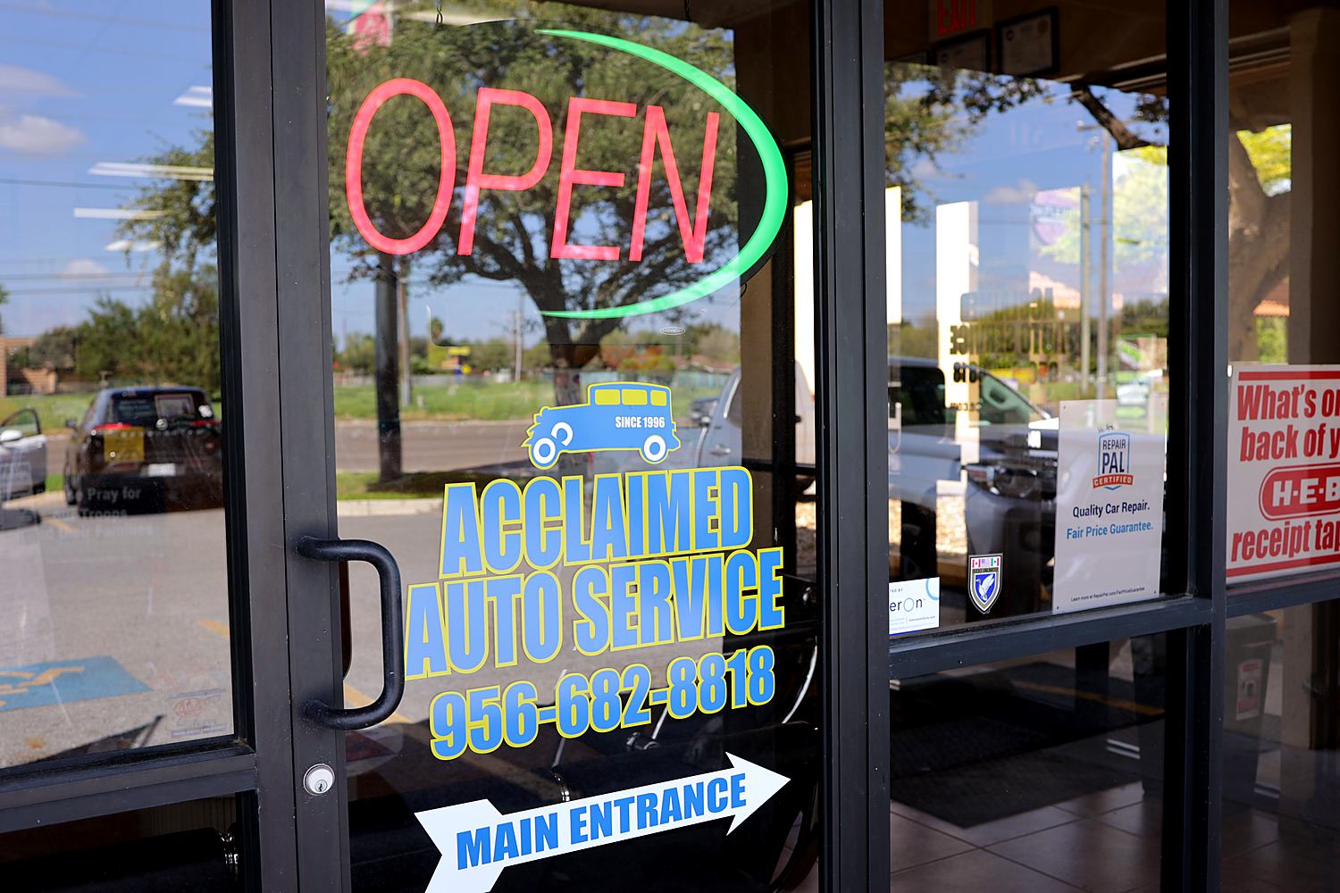Main entrance with the Acclaimed Auto Service logo and phone number
